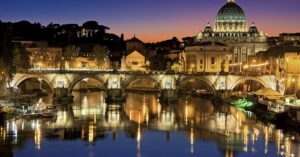 Beautiful view of Saint Peter's Basilica and St. Angelo Bridge in Rome at sunset reflecting in the Tiber River.