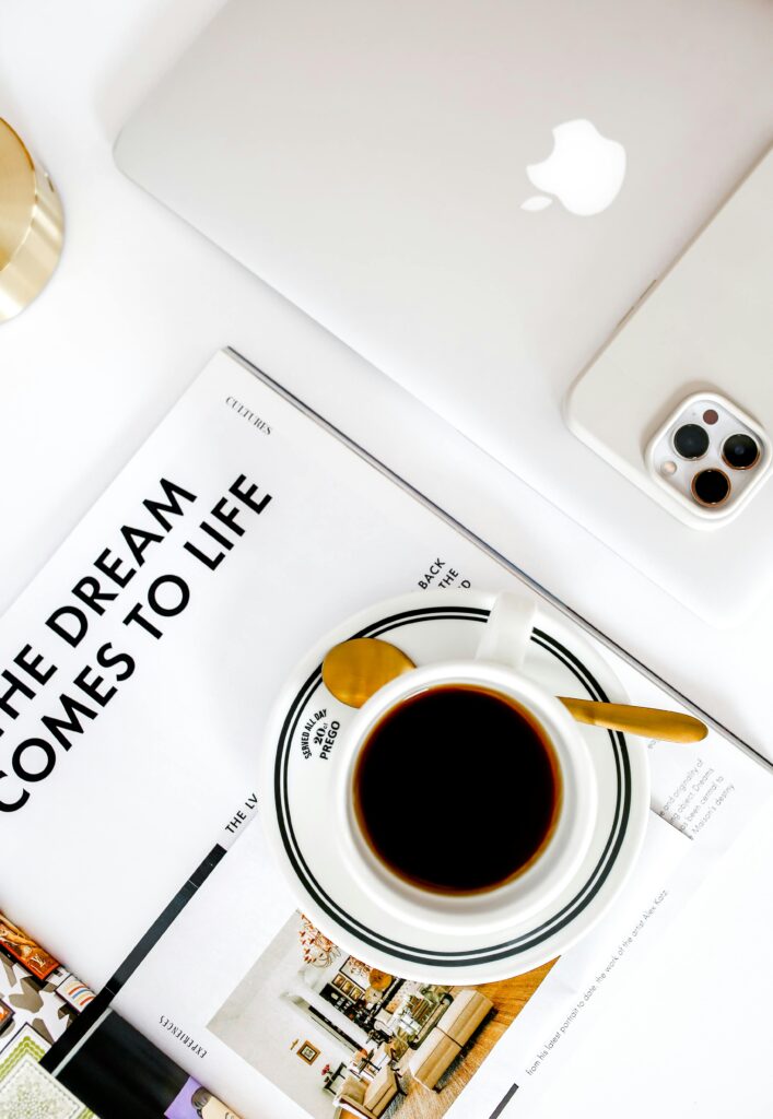 Top view of a modern workspace featuring coffee, a MacBook, and smartphone.