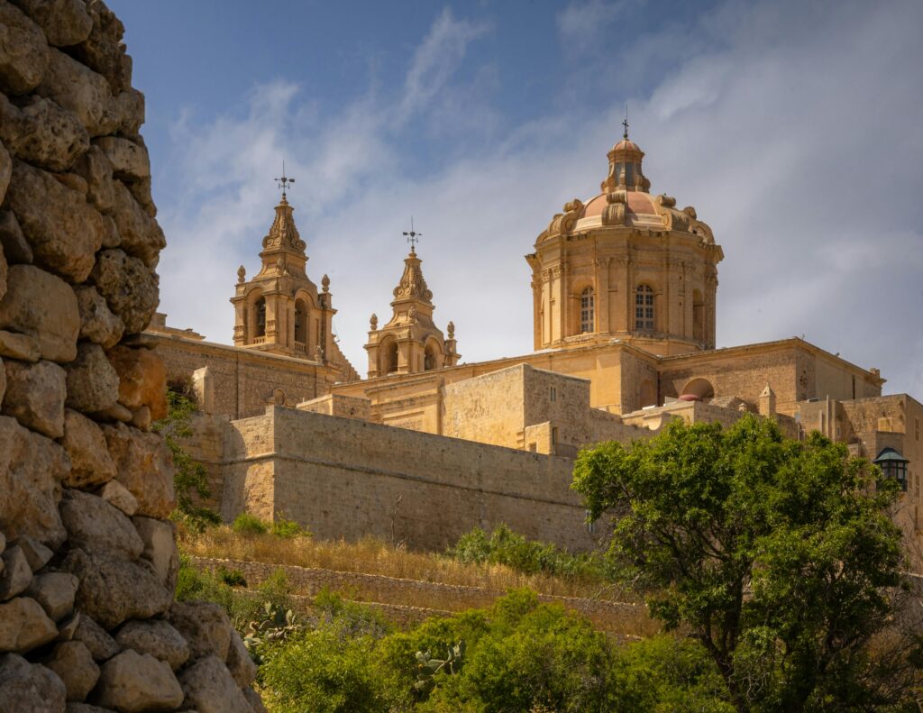 A stunning view of the historic Mdina Cathedral with clear blue skies, showcasing Maltese architecture.